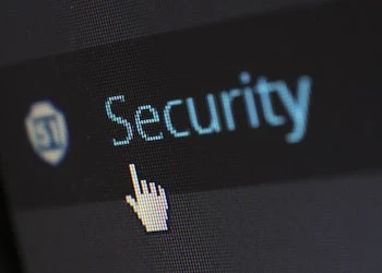 cursor hovering over security in blue writing on a computer screen with visible pixels and dark background